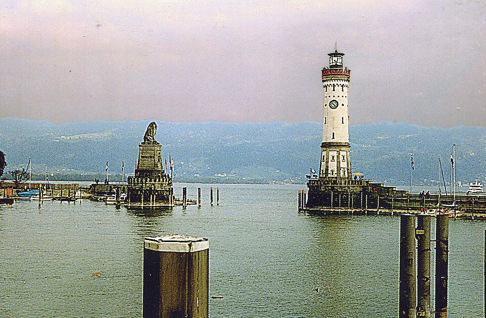 The seated stone Bavarian Lion facing the New Lighthouse across the harbour entrance at Lindau on Lake Constance.